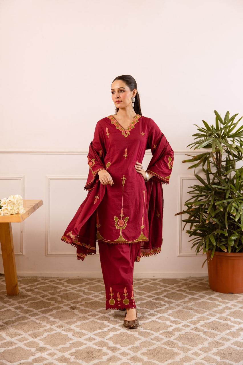 Maroon tunic with green and gold floral embroidery with matching pants.