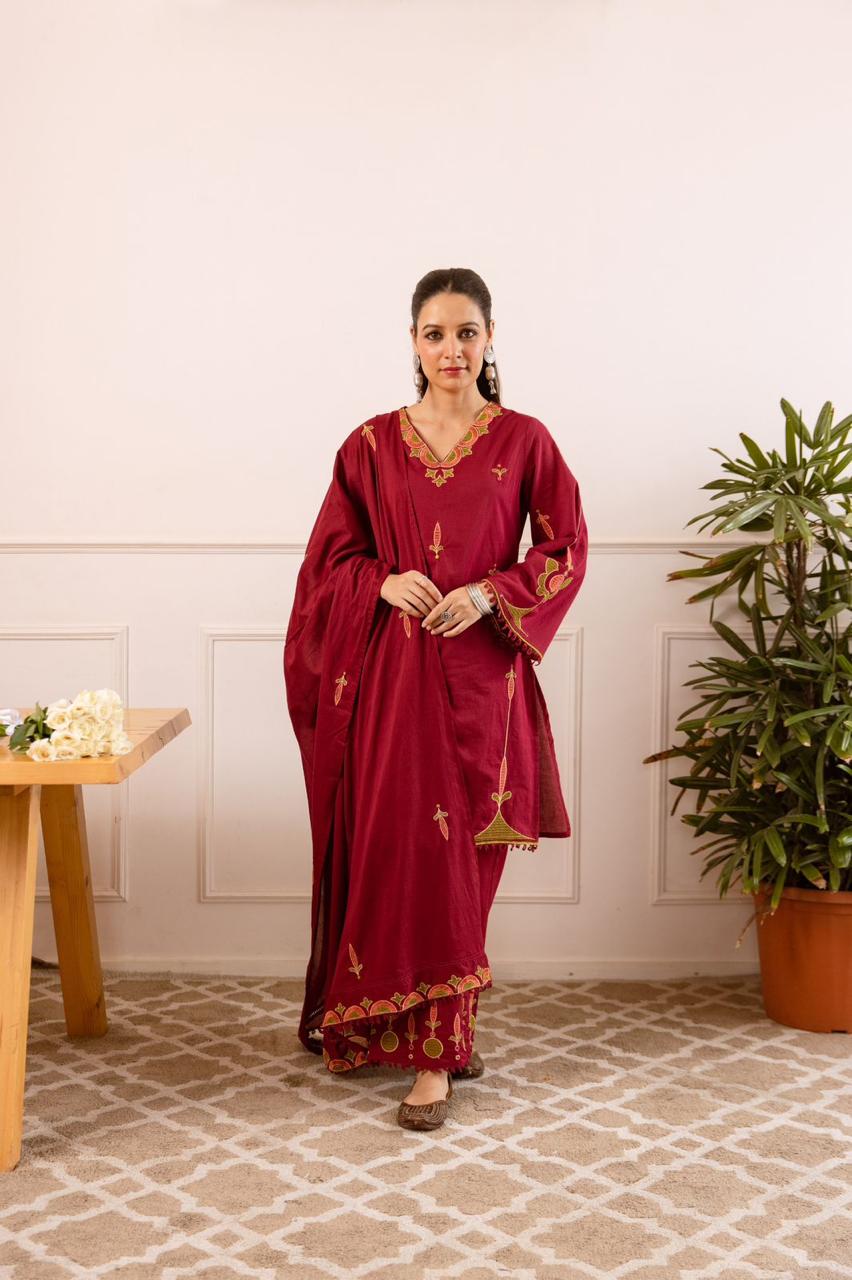 Maroon tunic with green and gold floral embroidery with matching pants.