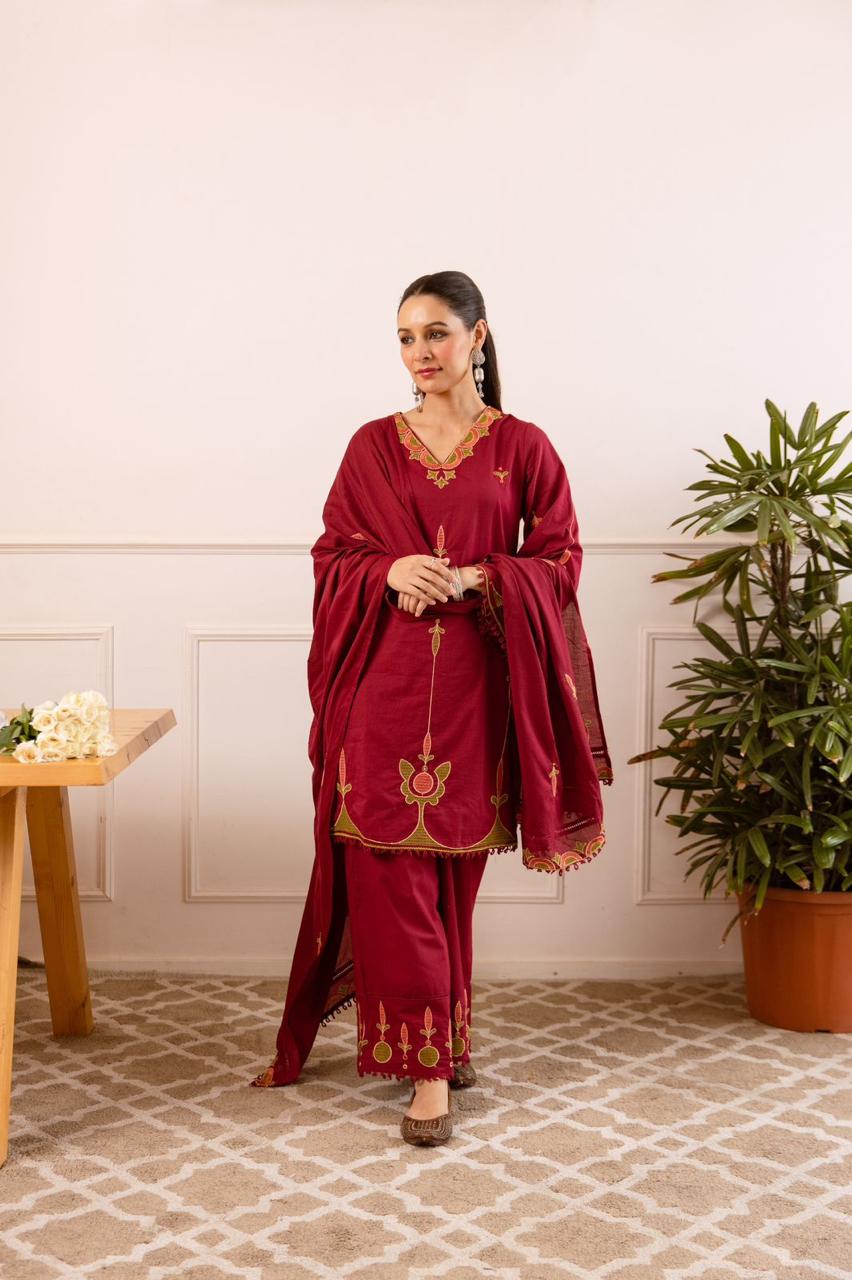Maroon tunic with green and gold floral embroidery with matching pants.