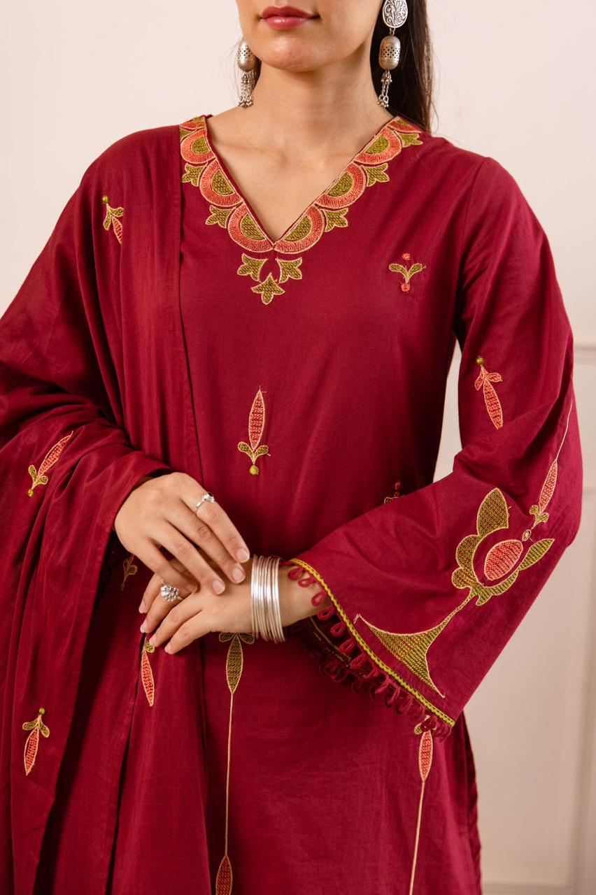 Maroon tunic with green and gold floral embroidery with matching pants.
